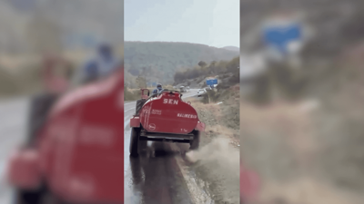 Bursa'da bir çiftçi, patlayan lastiğe rağmen yangına su taşıdı